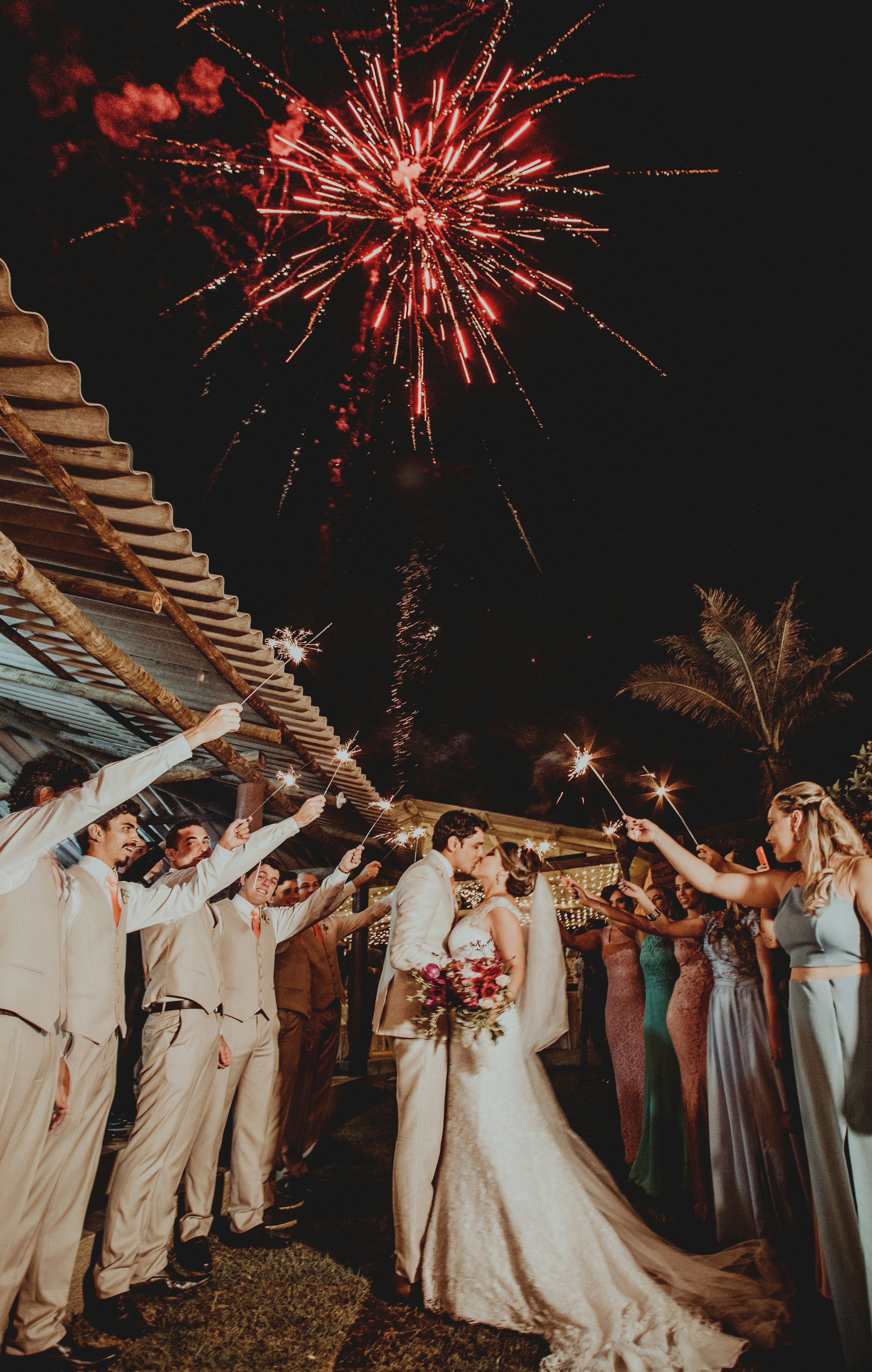 man and woman wedding couple kissing under fireworks